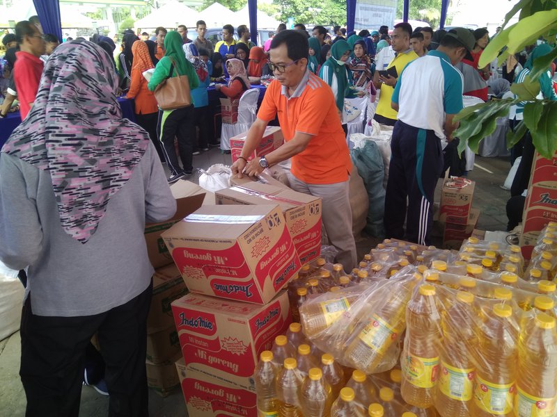SIBUK : Petugas dari Dinas Perindustrian Perdagangan Koperasi dan Usaha Mikro, Kabupaten Madiun sedang melayani penjualan empat jenis bahan pokok dalam pasar murah yang digelar di kawasan Alun-Alun Caruban, Jumat pagi 24 Mei 2019. Foto: Nd. Nugroho