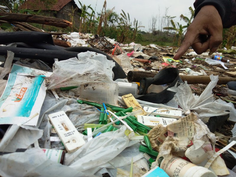 LIMBAH MEDIS. Seorang relawan menunjukkan sampah bekas pakai tes HIV di bantaran sungai Dinoyo Jalan Padangan, Kutorejo, Mojokerto pada Kamis, 5 Desember 2019. FOTO: Karina