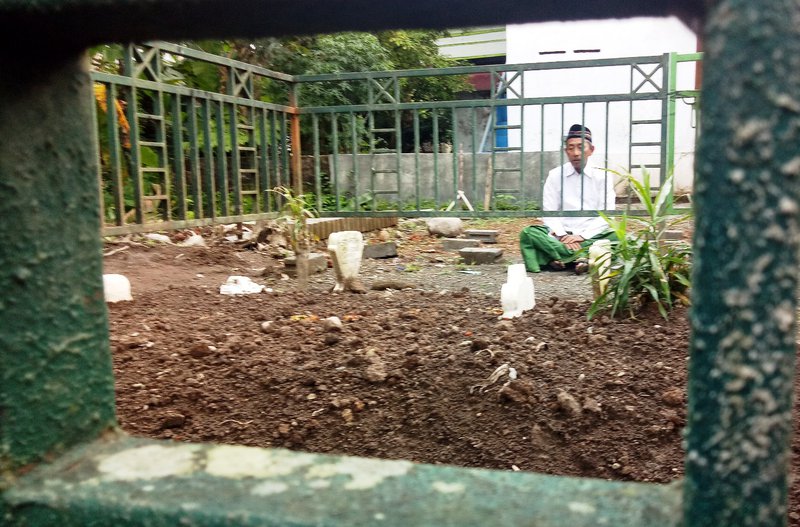 PUSARA. Putera kelima mendiang Kiai Anwar Sudibyo, Mohammad Munif, berdoa di depan pusara ayahnya. Makam Kiai Anwar dipindahkan pada Kamis 14 Maret 2019. Foto: IST.